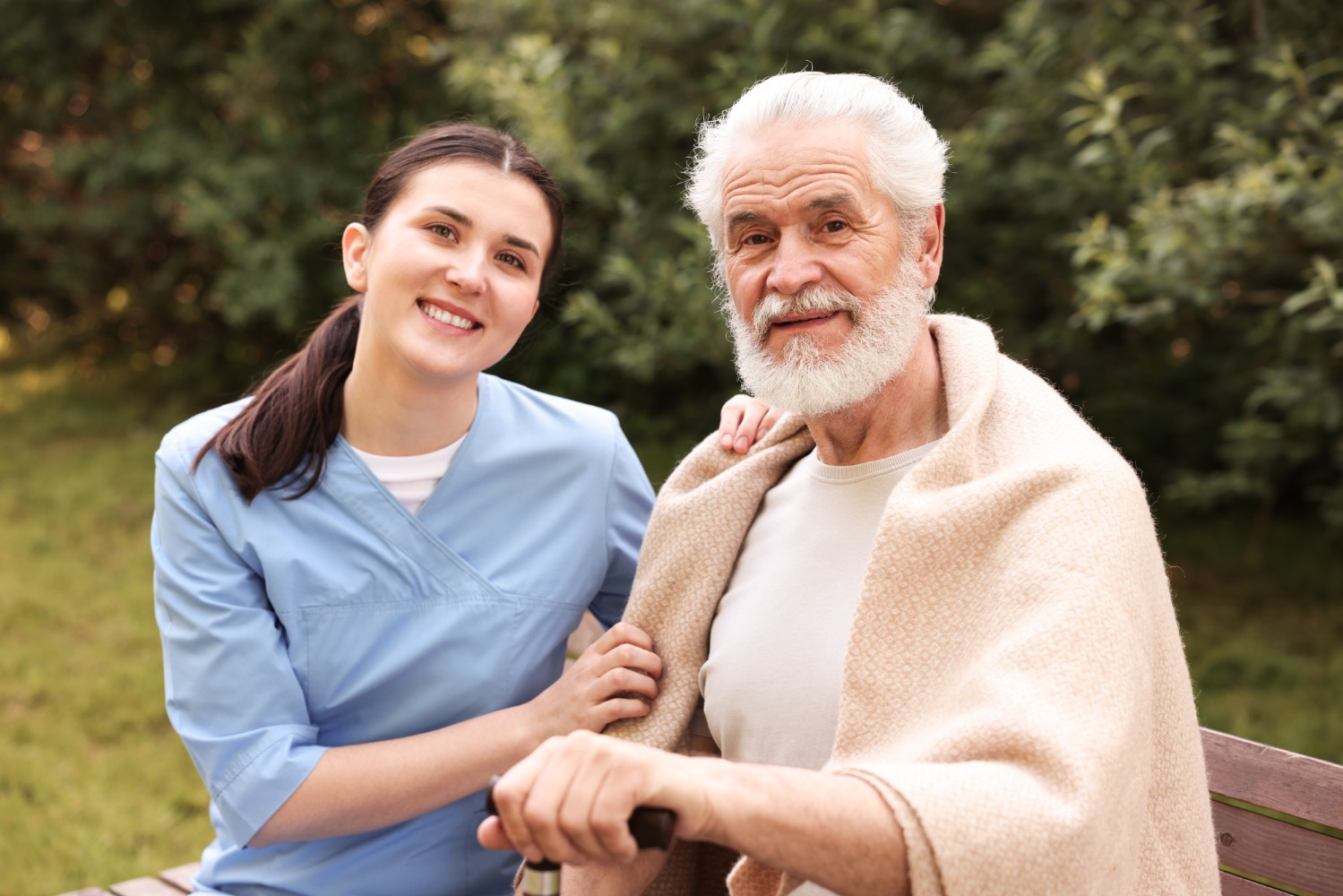 A caregiver and older adult smiling together